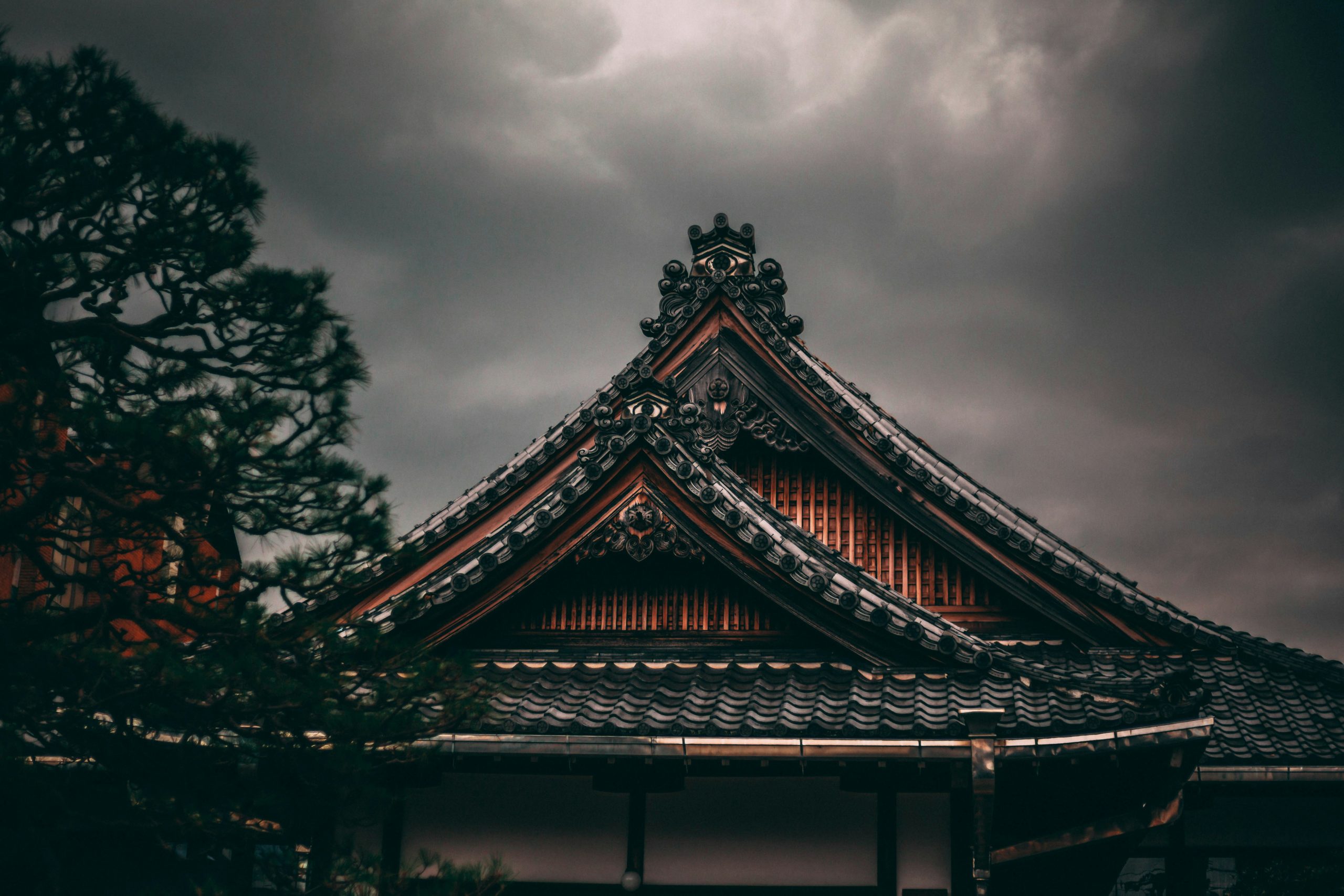 Traditional Japanese paper lanterns with red calligraphy text hanging in atmospheric lighting during Kyoto rainy season evening