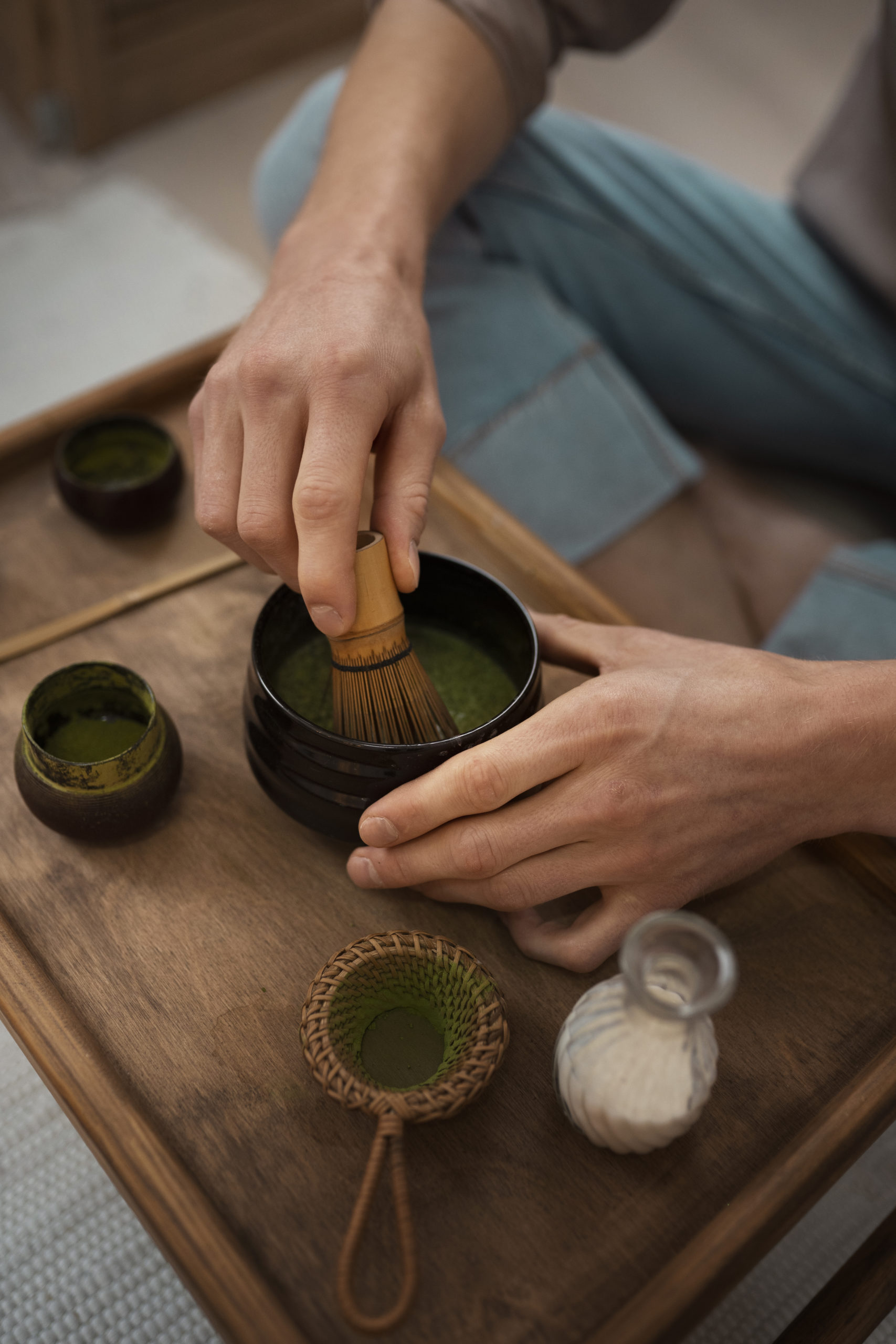 Hands performing traditional Japanese tea ceremony with matcha in authentic wooden setting demonstrating zen mindfulness and the connection between kimono wearing and ceremonial practices