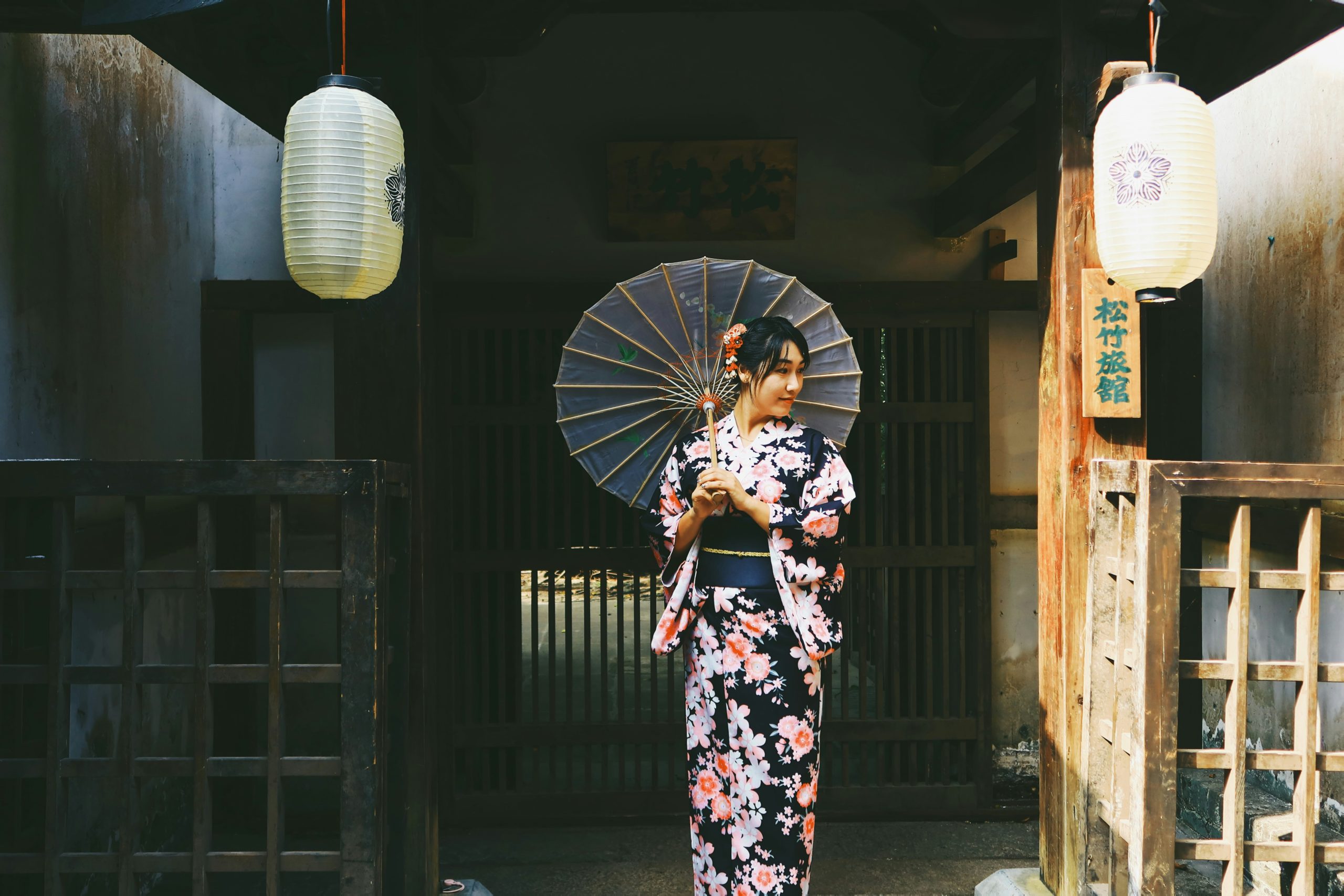Traditional Japanese temple scene with visitors carrying colorful umbrellas in the rain creating atmospheric mood for kimono photography