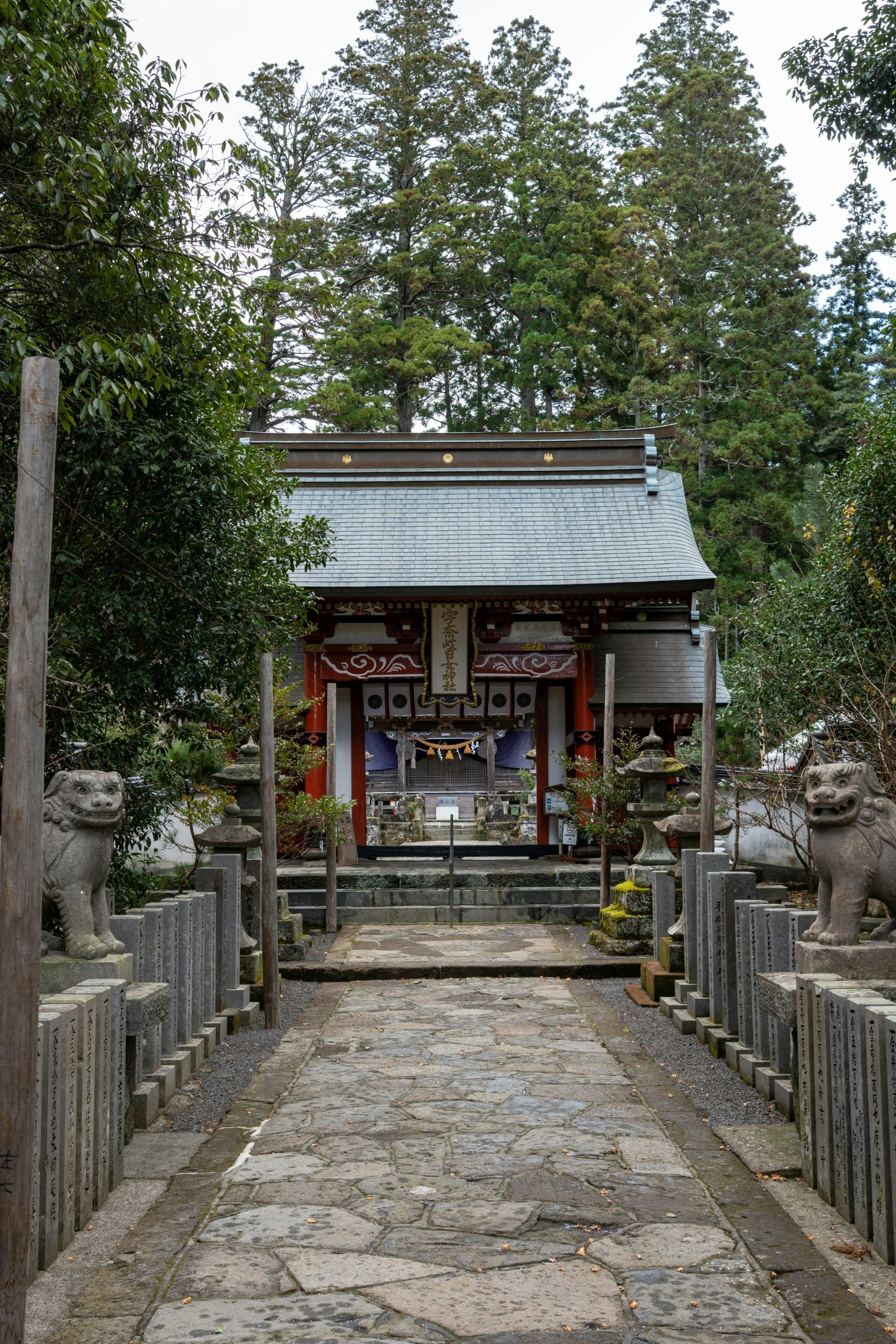 Traditional Japanese shrine pathway with stone statues, lanterns, and wooden construction creating serene spiritual atmosphere perfect for kimono photography