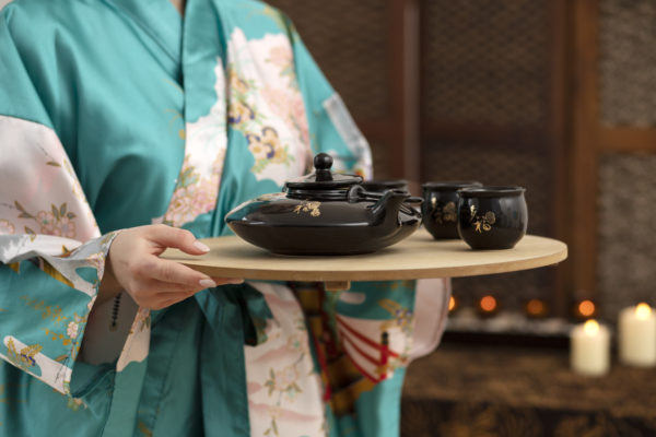 Traditional Japanese tea ceremony in Gion district featuring participants in elegant kimono, showcasing the living continuation of poetic kimono culture in modern Kyoto's cultural experiences