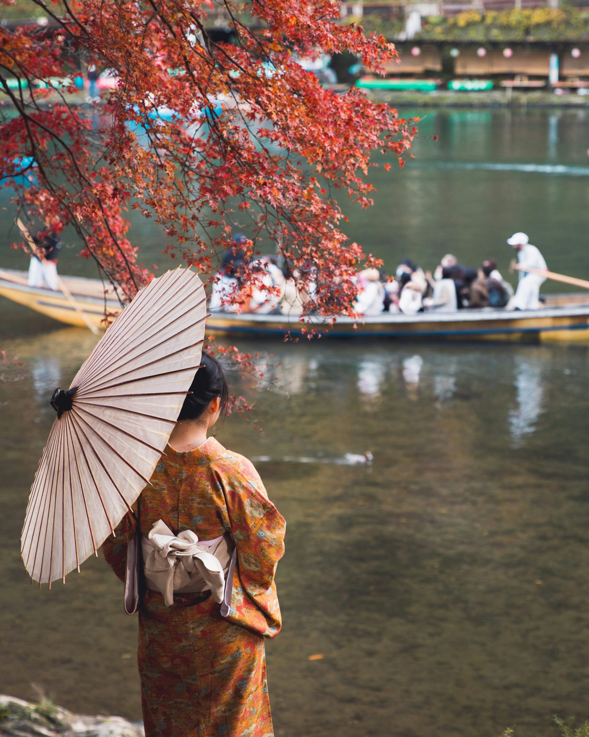 The iconic Togetsukyo Bridge spanning across the Hozu River in Arashiyama with traditional architecture and surrounding mountains creating a picturesque landscape