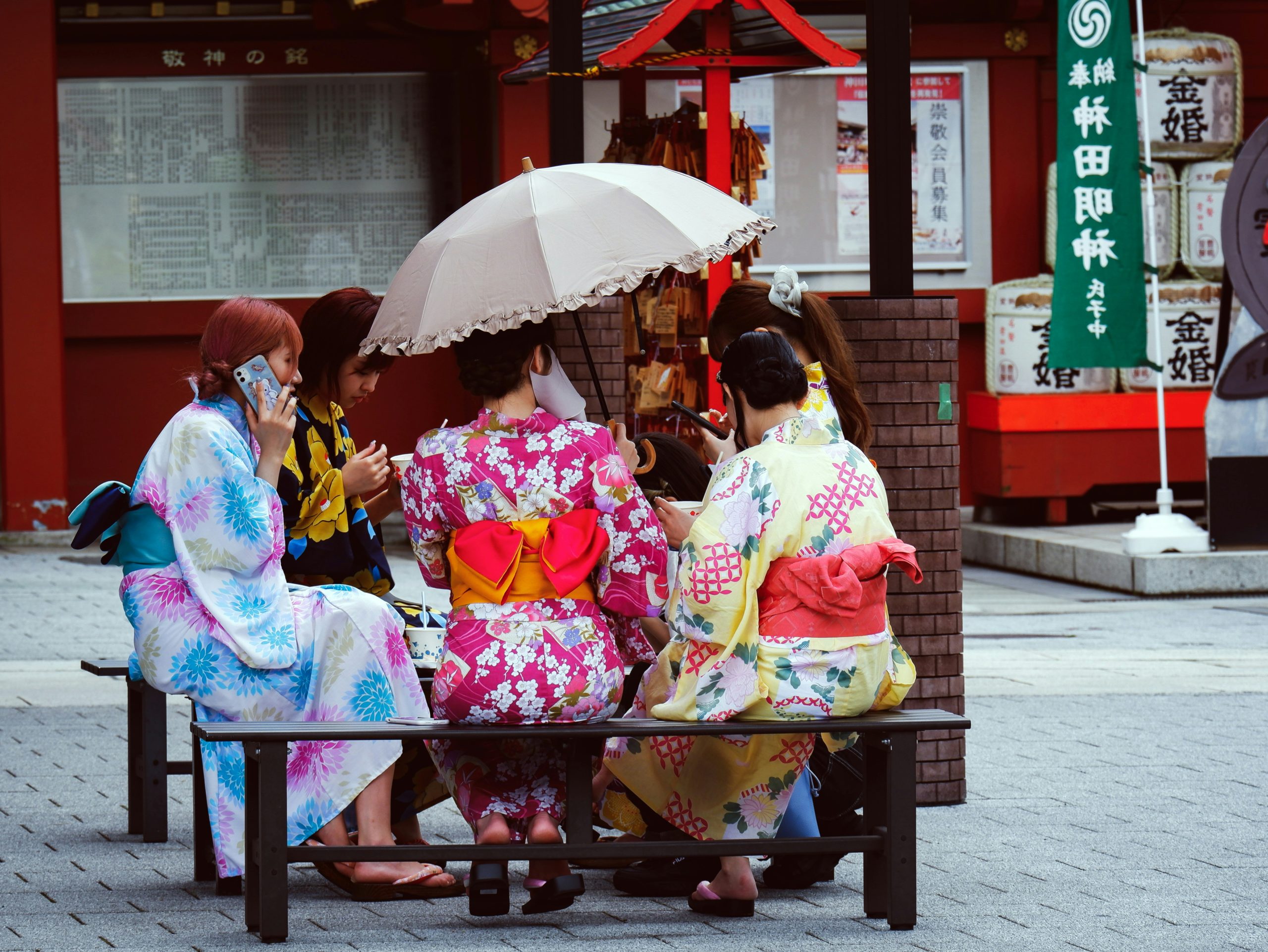 Group of friends in kimono enjoying traditional Japanese tea ceremony and matcha in historic Kyoto setting