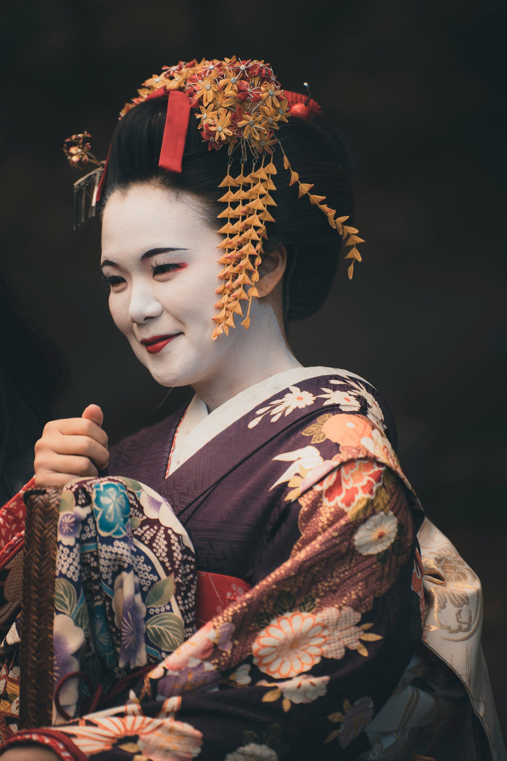 Atmospheric street scene in Kyoto's historic Gion district showing traditional architecture and people in kimono walking along historic cobblestone streets, epitomizing Japanese cultural heritage