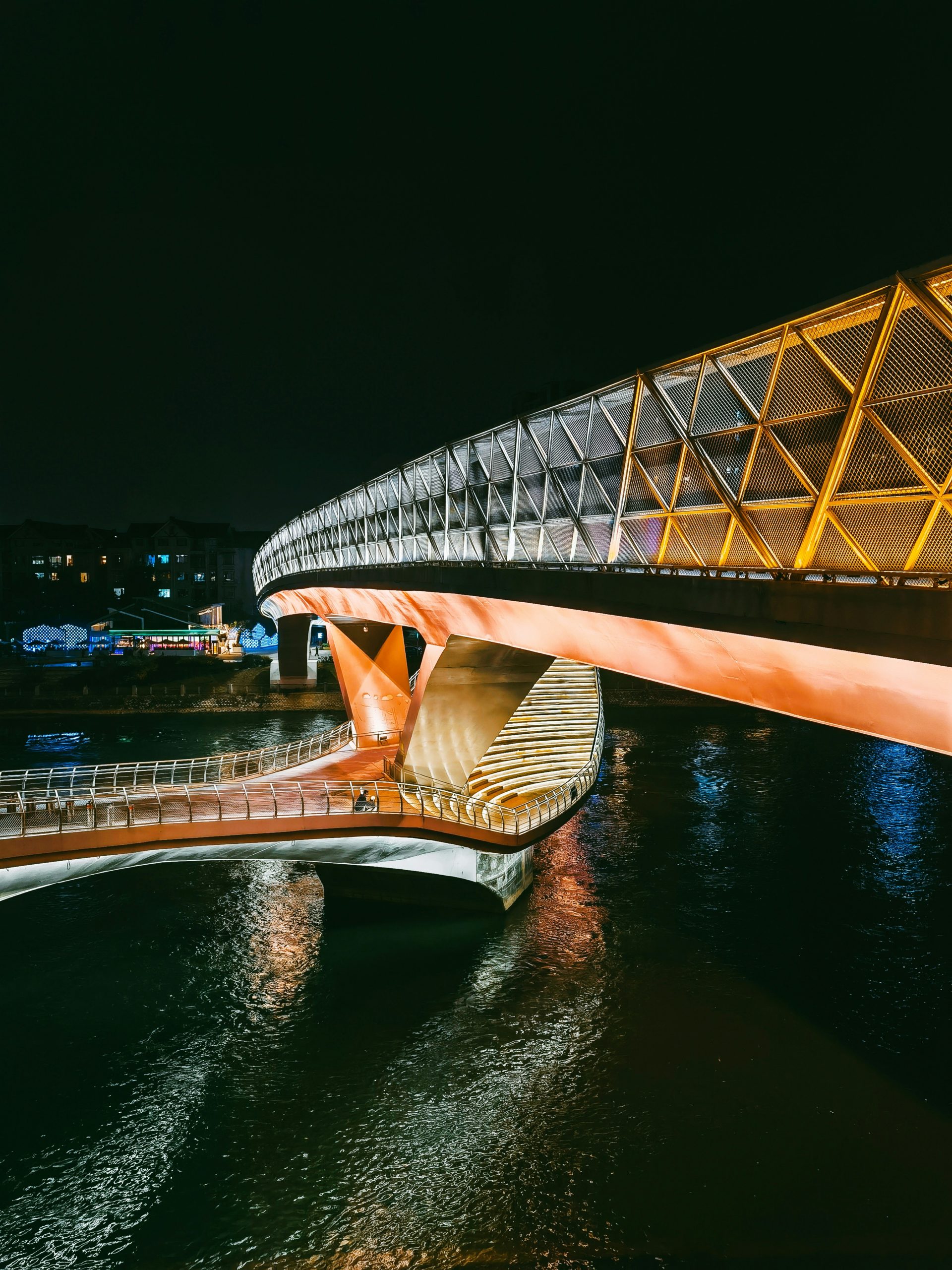 Togetsukyo Bridge in Arashiyama illuminated during Hanatoro festival with lanterns reflecting in the Katsura River at night in Kyoto, Japan