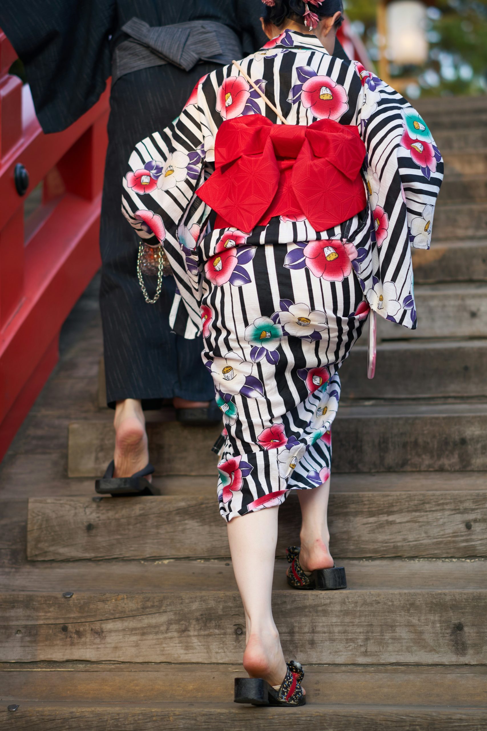 Japanese woman wearing elegant traditional kimono at historic shrine temple in Kyoto with traditional architecture in background