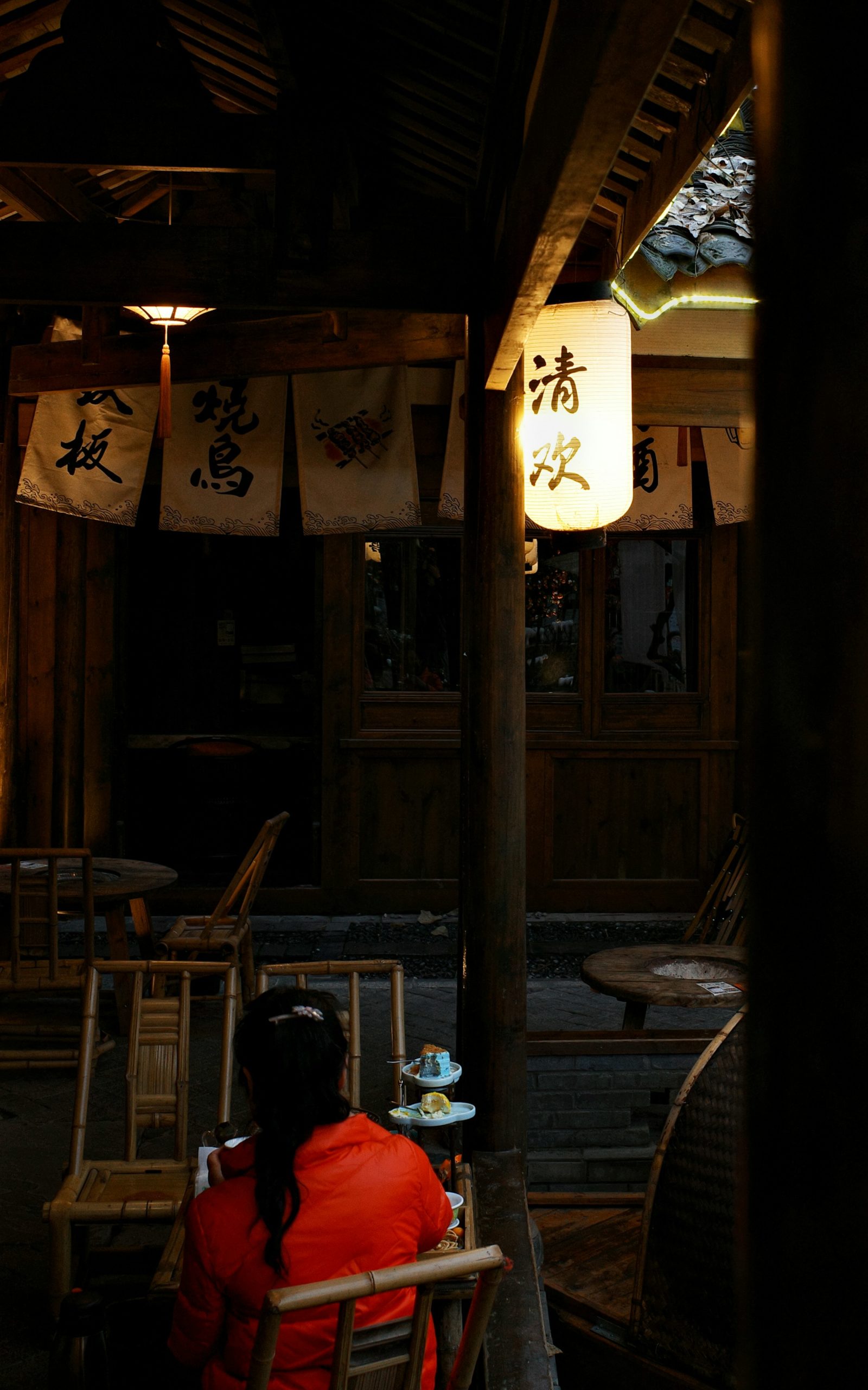 Night view of Shirakawa River in Gion district Kyoto with illuminated cherry blossoms reflecting on water traditional Japanese wooden buildings and lanterns creating romantic atmosphere for evening hanami