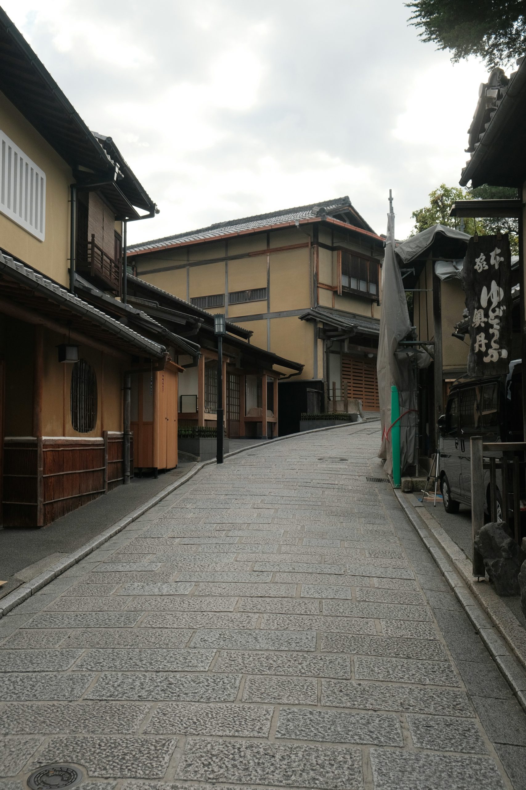 Woman wearing traditional kimono walking on historic Higashiyama street in Kyoto with Hokan-ji Temple pagoda in background